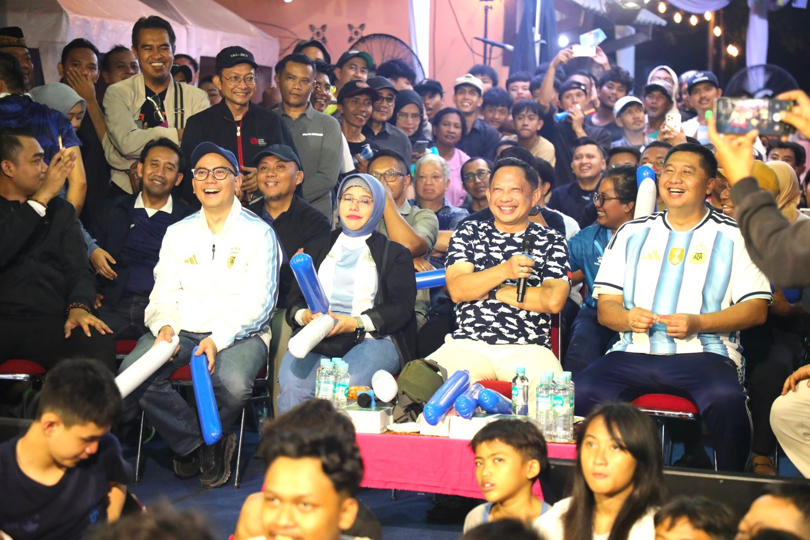 Menteri Dalam Negeri Muhammad Tito Karnavian, Menteri Perumahan dan Kawasan Permukiman Maruarar Sirait, serta Kepala Badan Pusat Statistik Amalia Adininggar Widyasanti bersama warga menyaksikan nonton bareng final Piala Dunia 2026 Argentina versus Spanyol di Menteng Tenggulun, Jakarta.