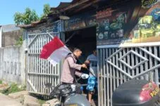 Bhabinkamtibmas Pasang Bendera di Halaman Warga Gowa