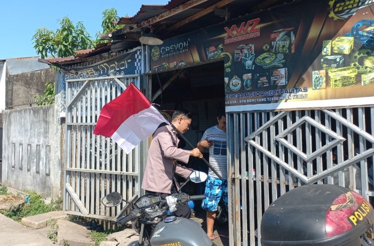 Bhabinkamtibmas Pasang Bendera di Halaman Warga Gowa