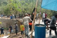 Personel TNI dan warga bergotong royong membangun Jembatan Merah Putih di Desa Suka Maju, Sinjai.