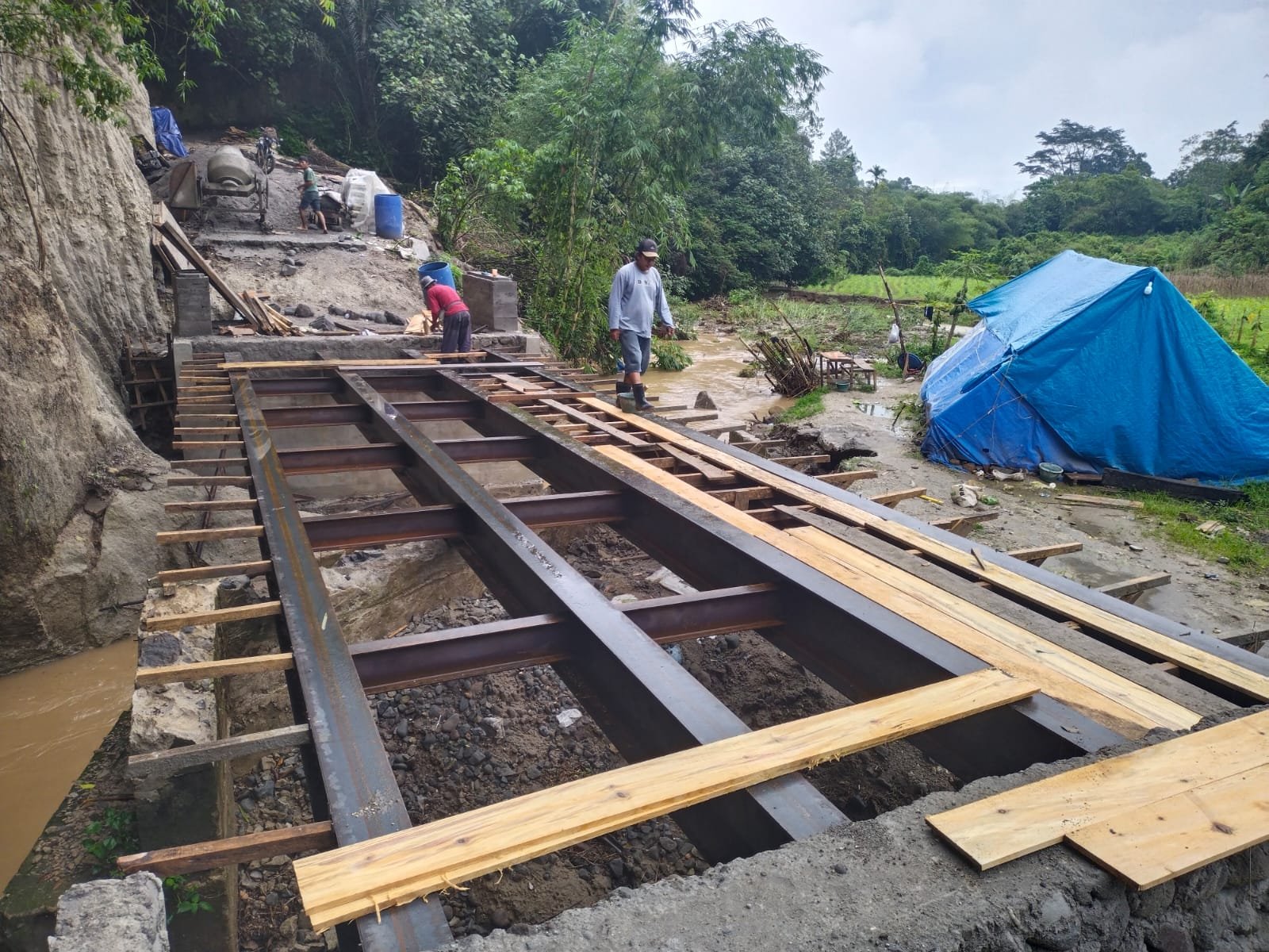 Personel Kodim 0205/Tanah Karo bersama masyarakat bergotong royong mengerjakan pembangunan Jembatan Beton Tahap VII A di Desa Juhar Ginting, Kecamatan Juhar, Kabupaten Karo, Sumatera Utara.