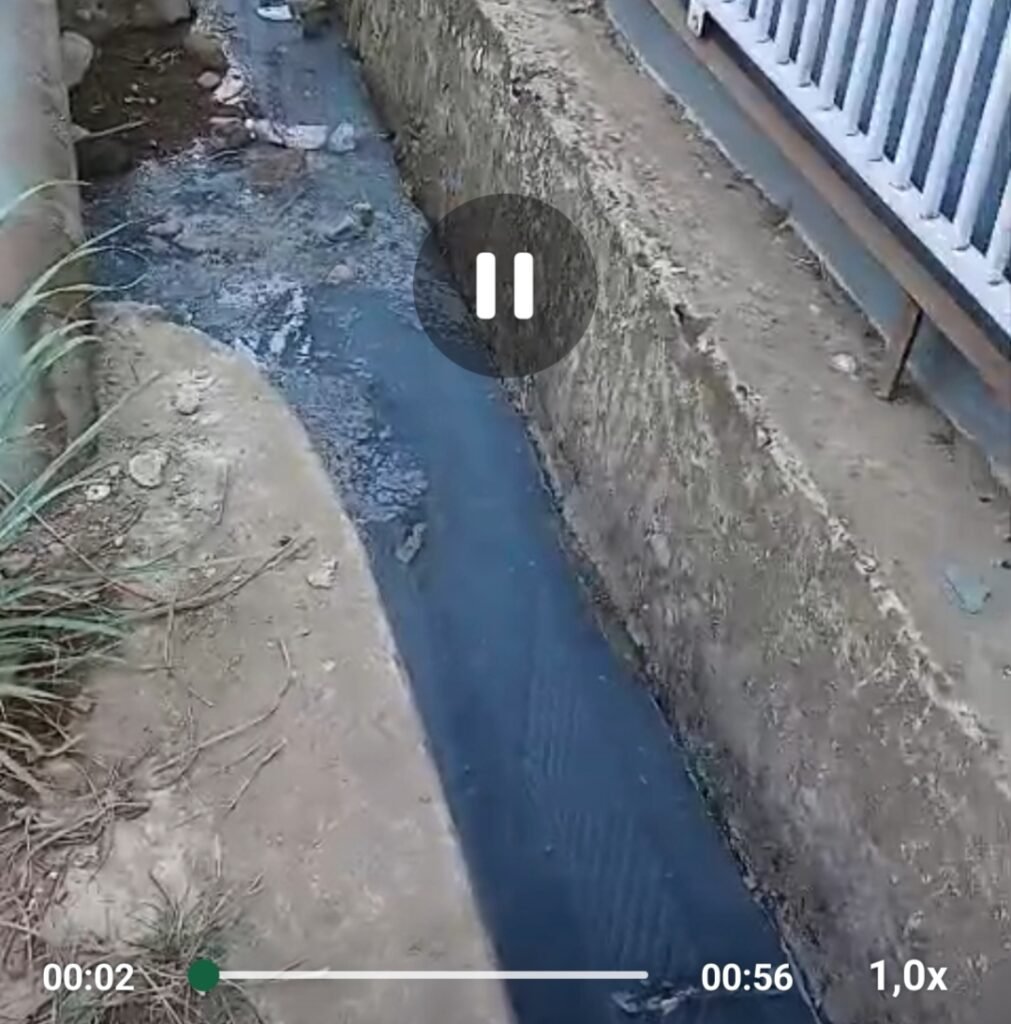Saluran irigasi di depan SPPG Singaserri, Kabupaten Sinjai, dengan sampah di sekitar saluran.