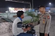 Petugas kepolisian berbincang dengan pria berbaju krem berkerah biru dan bercorak hitam pada lengan di Kecamatan Mandor, Kabupaten Landak.
