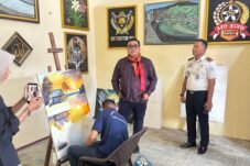 Kalapas Ahmad kanan berbincang dengan Rico tengah dan Warga binaan sedang melukis sebuah pemandangan lingkungan kehidupan sehari-hari di alam bebas.