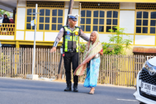 Personel Unit Lantas Polsek Ujung Polres Parepare membantu warga menyeberang jalan saat pelayanan pagi, Senin (19/10/2026).